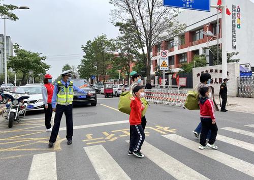 郑东新区实验幼儿园门口，交警在园区附近筑起一道安全屏障
