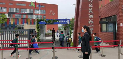 郑东新区昆丽河小学学生保持合理间距排队入校