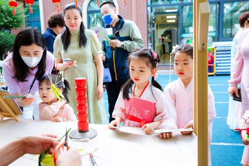 孩子们专注地看着非遗艺人编织