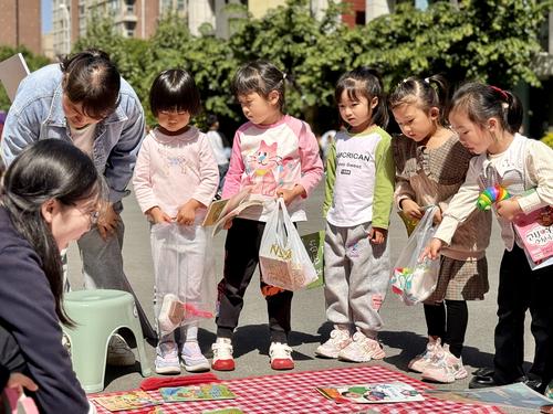 孩子们围在摊位前挑选自己喜欢的图书